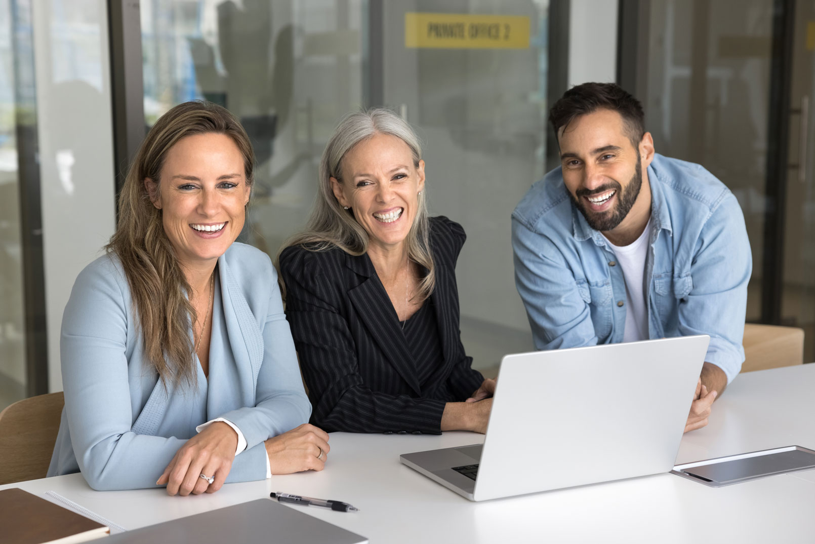 Three people collaborating on a laptop.
